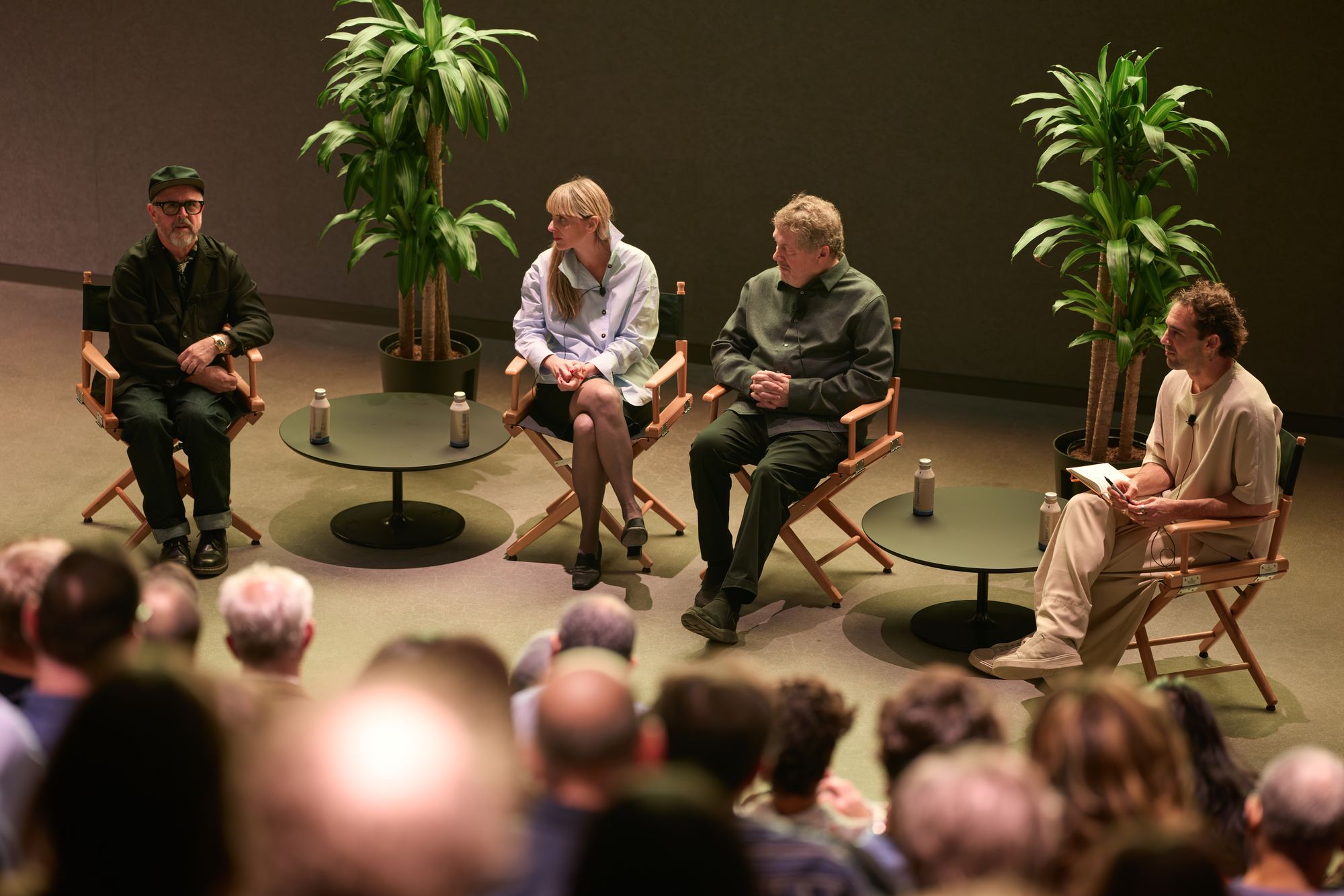 From above, the panelists sit in directors' chairs.